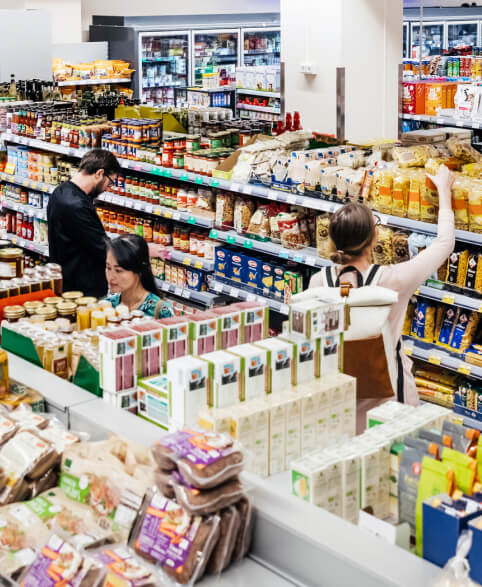 People shopping in grocery store aisle