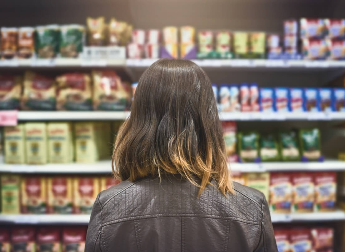 The back of a woman's head who is looking at products on a shelf